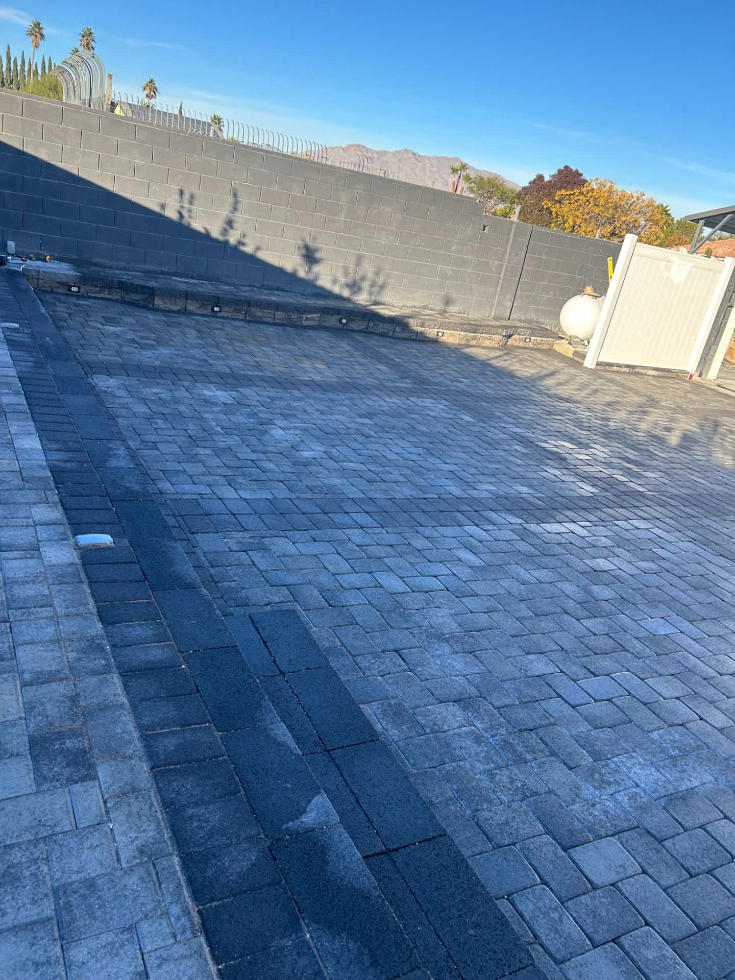 Paver driveway installation with accent border and landscape lighting